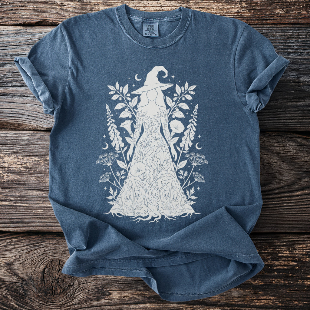 Blue t-shirt with white line art of a woman in a floral dress and witch hat.