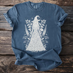 Blue t-shirt with white line art of a woman in a floral dress and witch hat.