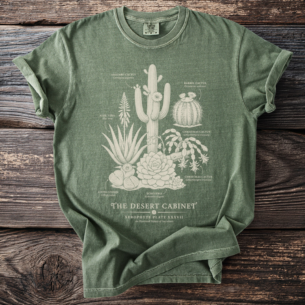 Green t-shirt with "The Desert Cabinet" botanical illustration of various succulents.