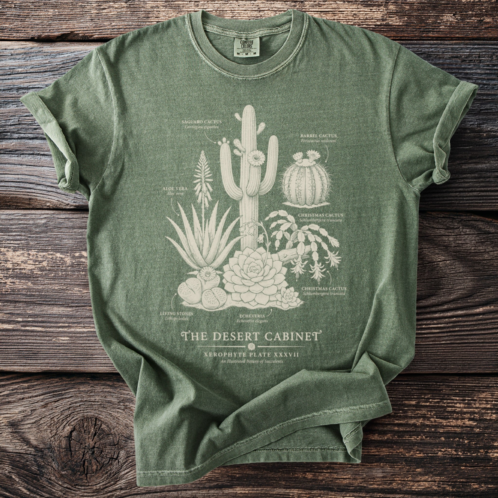 Green t-shirt with "The Desert Cabinet" botanical illustration of various succulents.