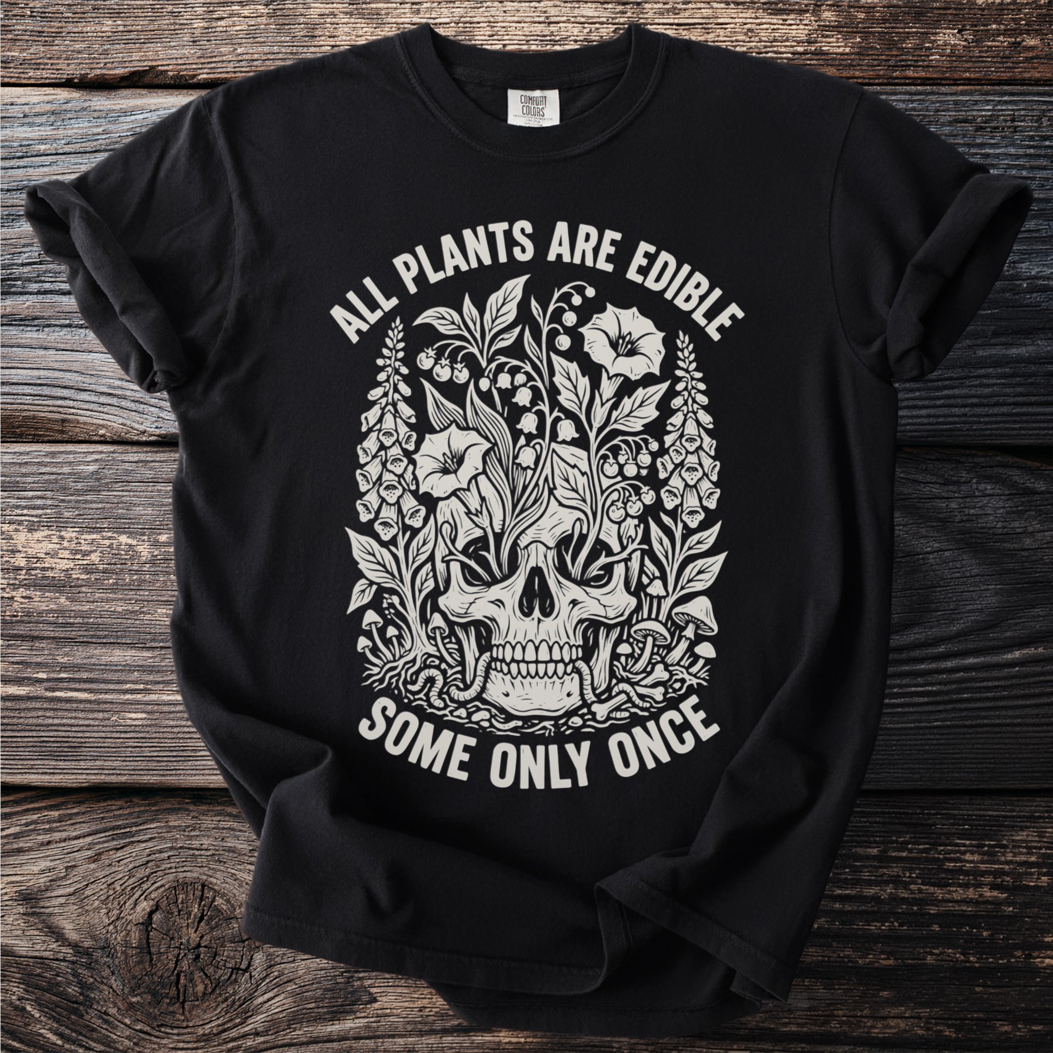 Black t-shirt with white graphic of a skull entwined with plants and text.