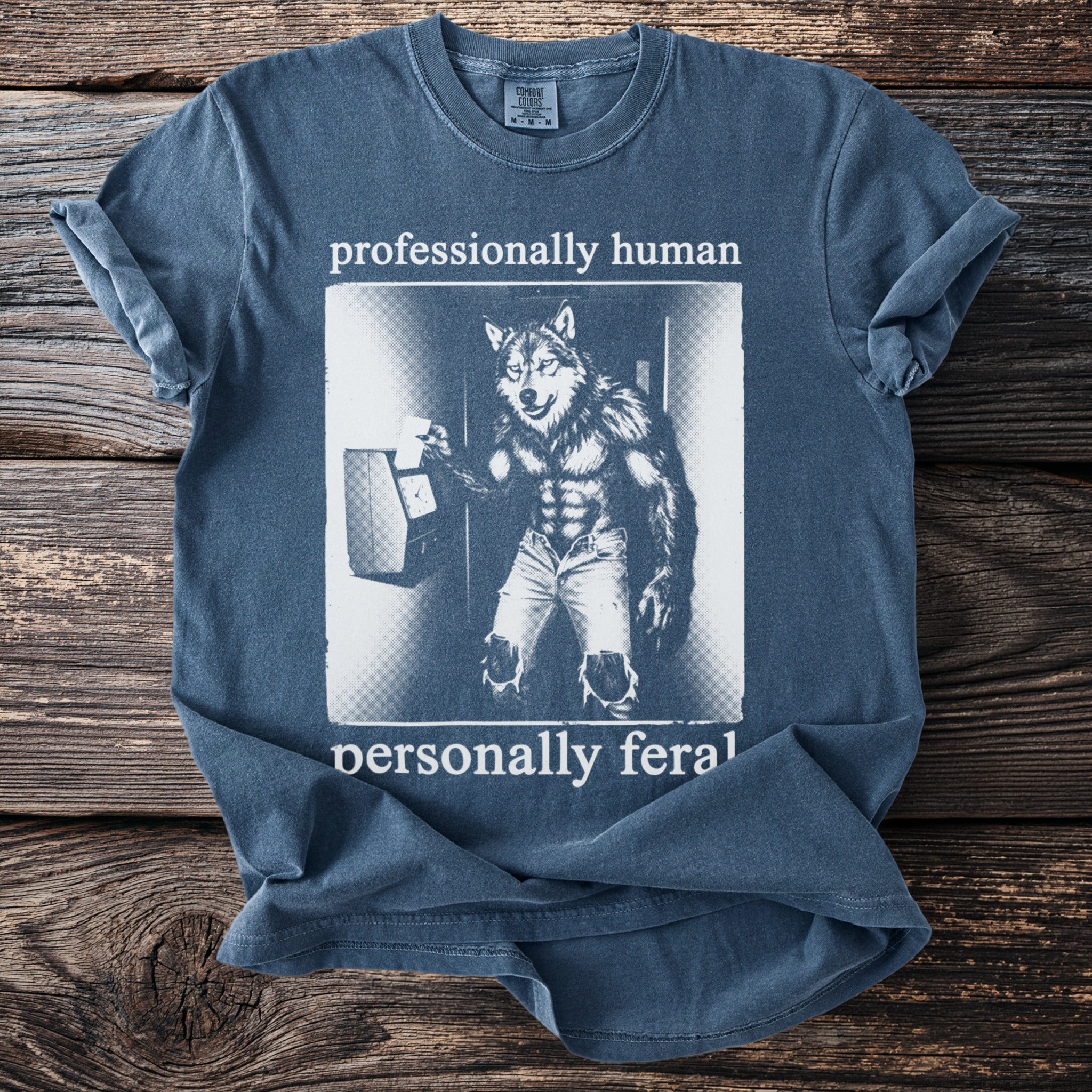 T-shirt with werewolf at time clock and text "professionally human personally feral."