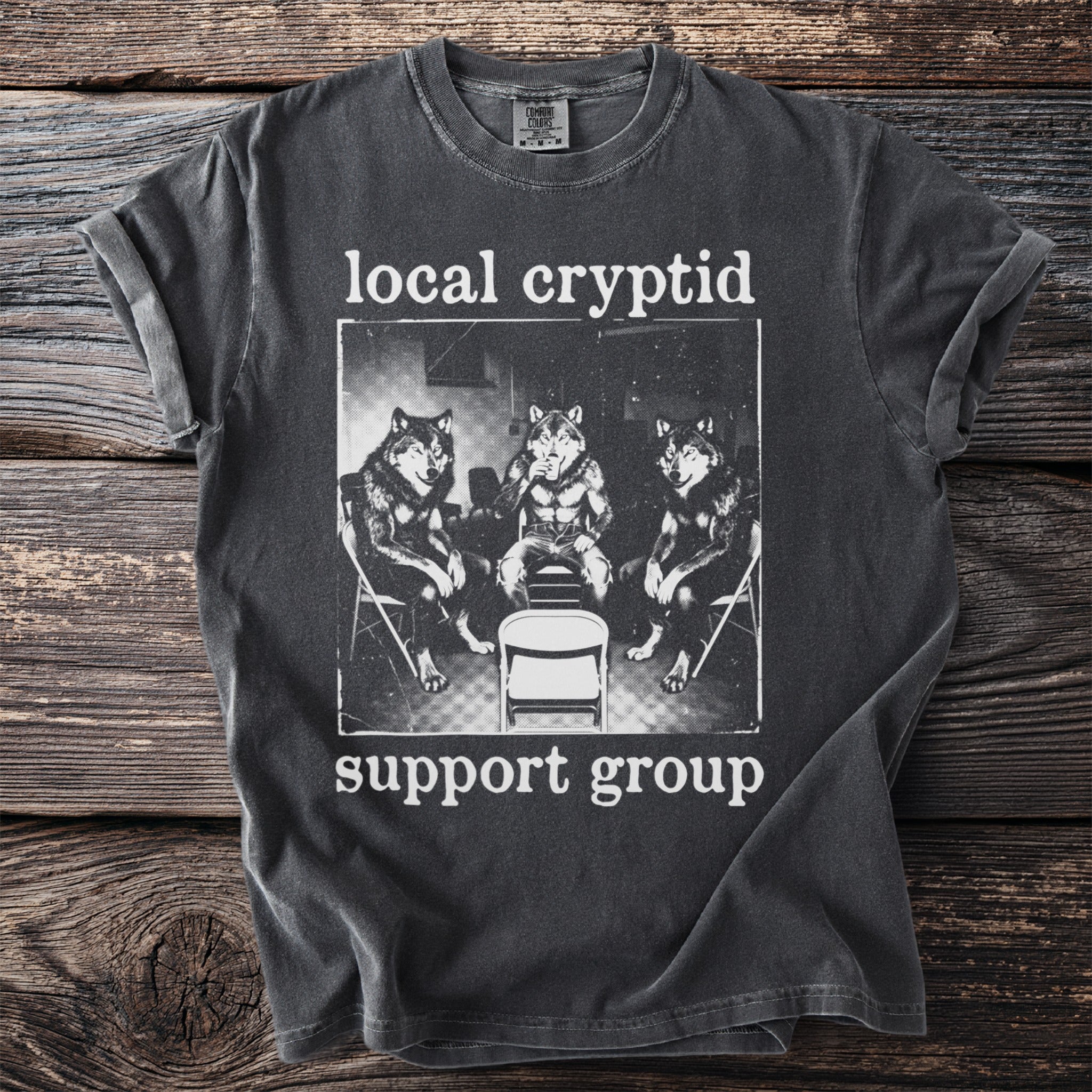 Dark grey t-shirt with "local cryptid support group" and wolf illustration.