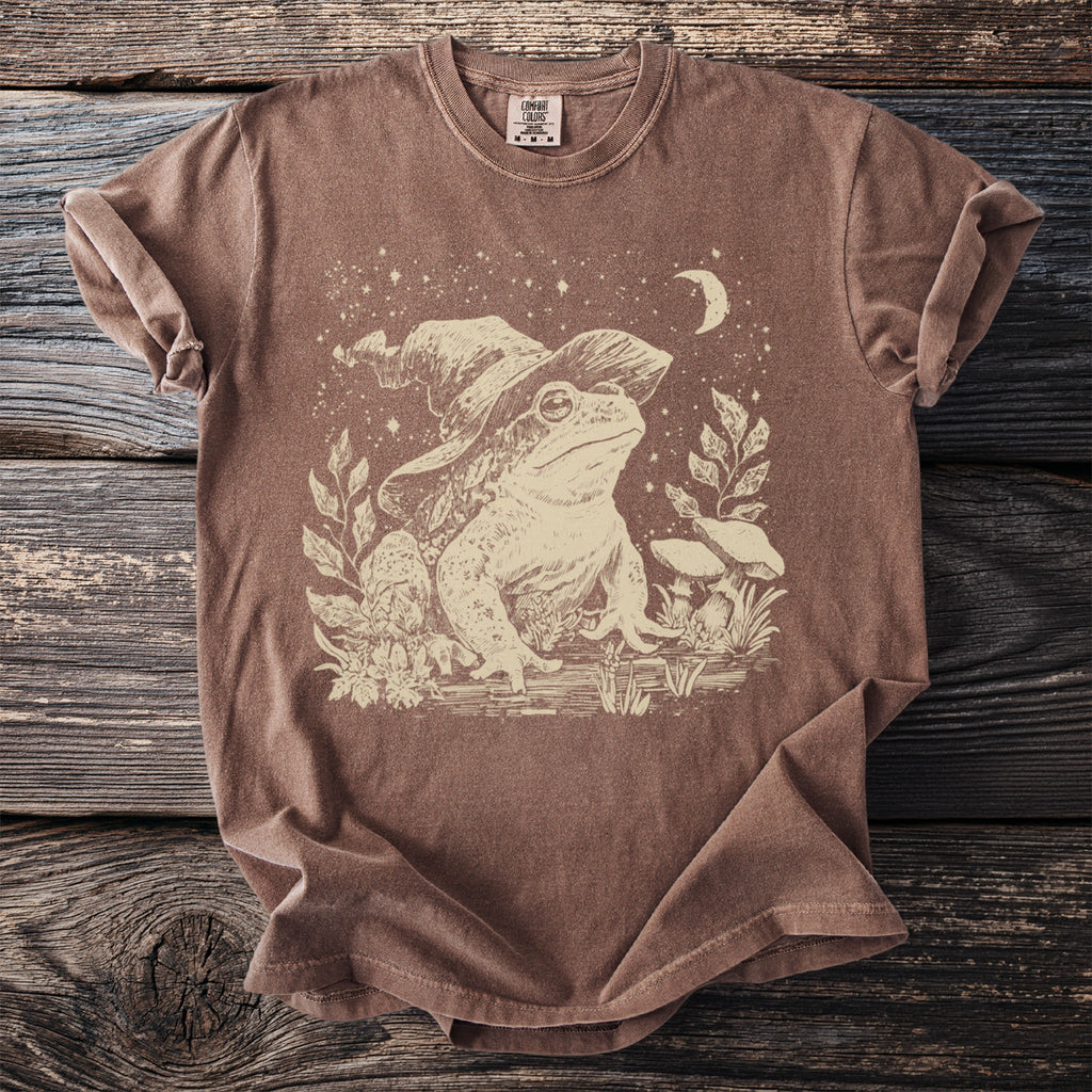 Brown t-shirt with a faded graphic of a frog wearing a wizard hat.