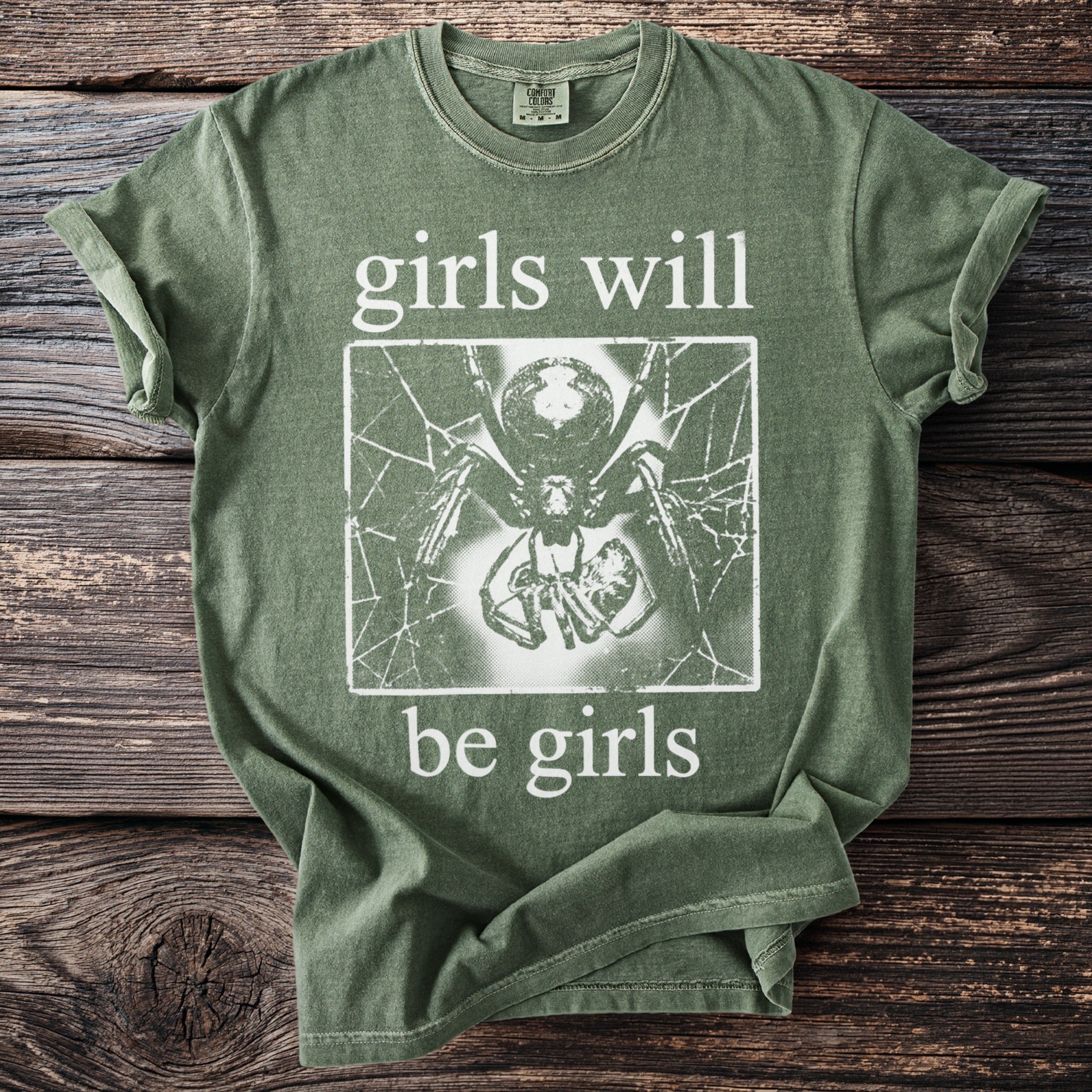 Green t-shirt with "girls will be girls" text and spider graphic.