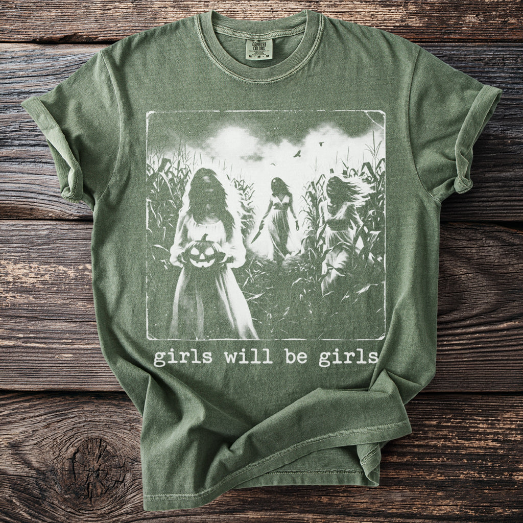 Green t-shirt with girls holding a pumpkin and knives in a cornfield.