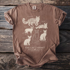 Brown t-shirt with white line art of six cat breeds titled "The Cat Cabinet"
