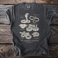 Dark gray t-shirt featuring scientific illustrations of six snakes and their names, with title "The Serpent Studies".