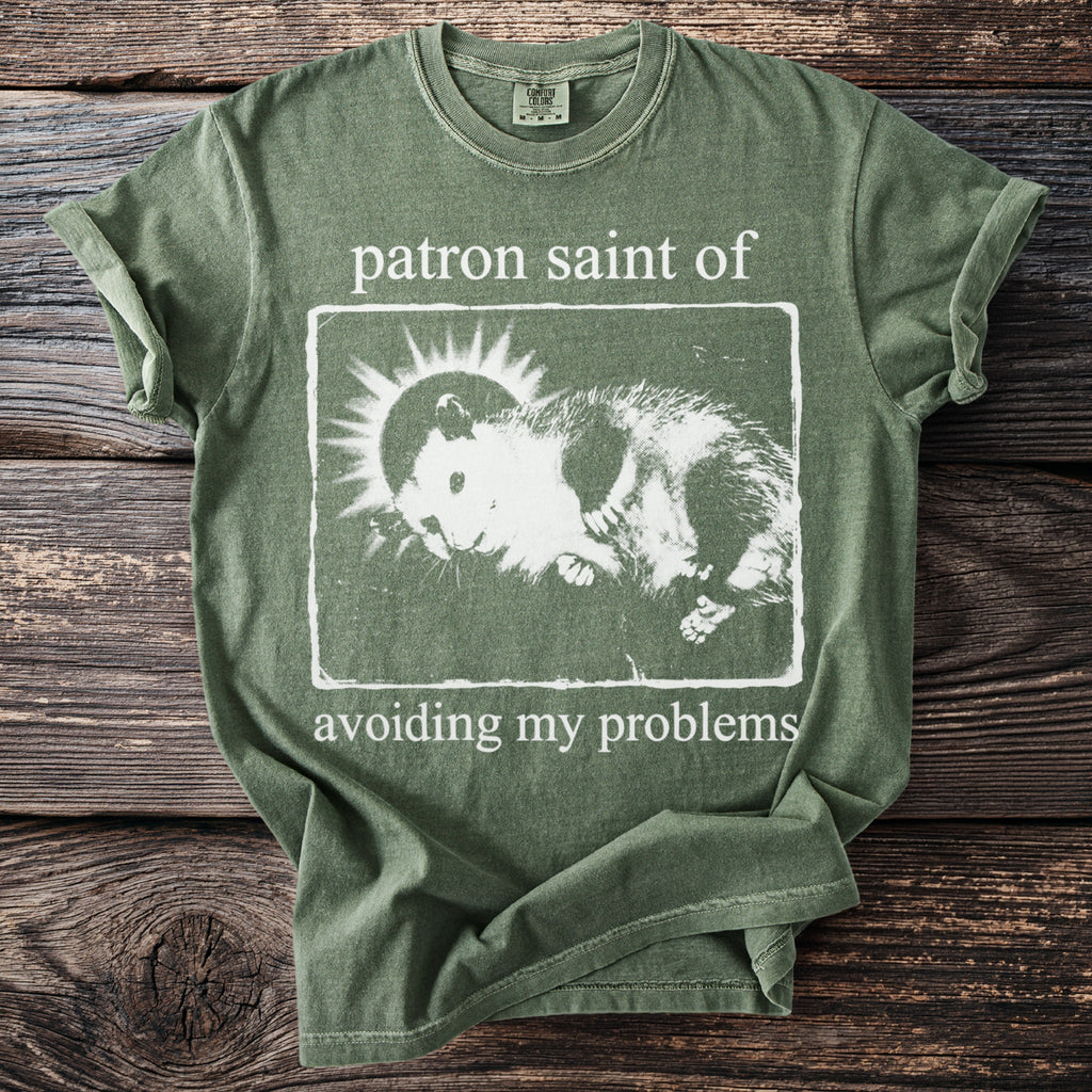 Sage green t-shirt with a distressed print of a hamster and sun surrounded by text.