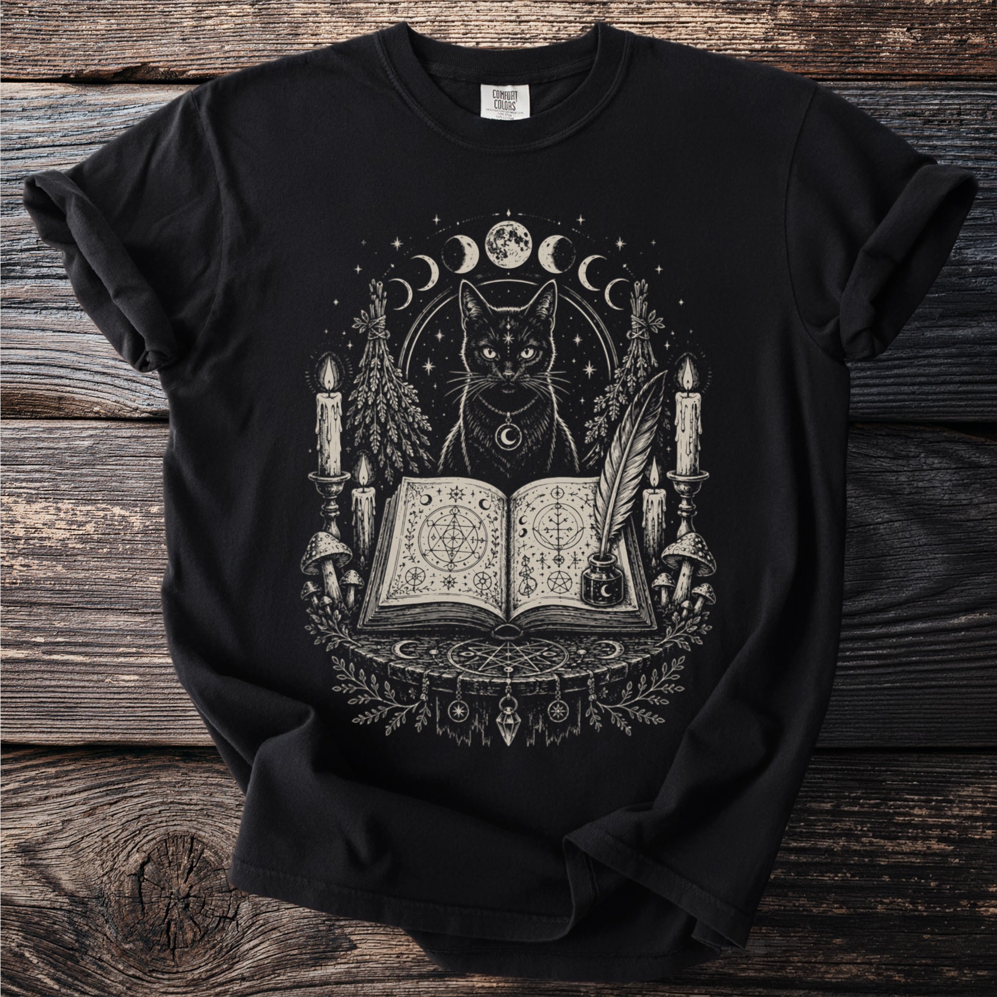 Black t-shirt with a gothic illustration of a black cat, moons, candles, and an open book.