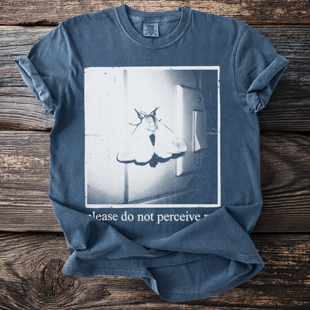 Blue t-shirt with a moth graphic and text "please do not perceive".