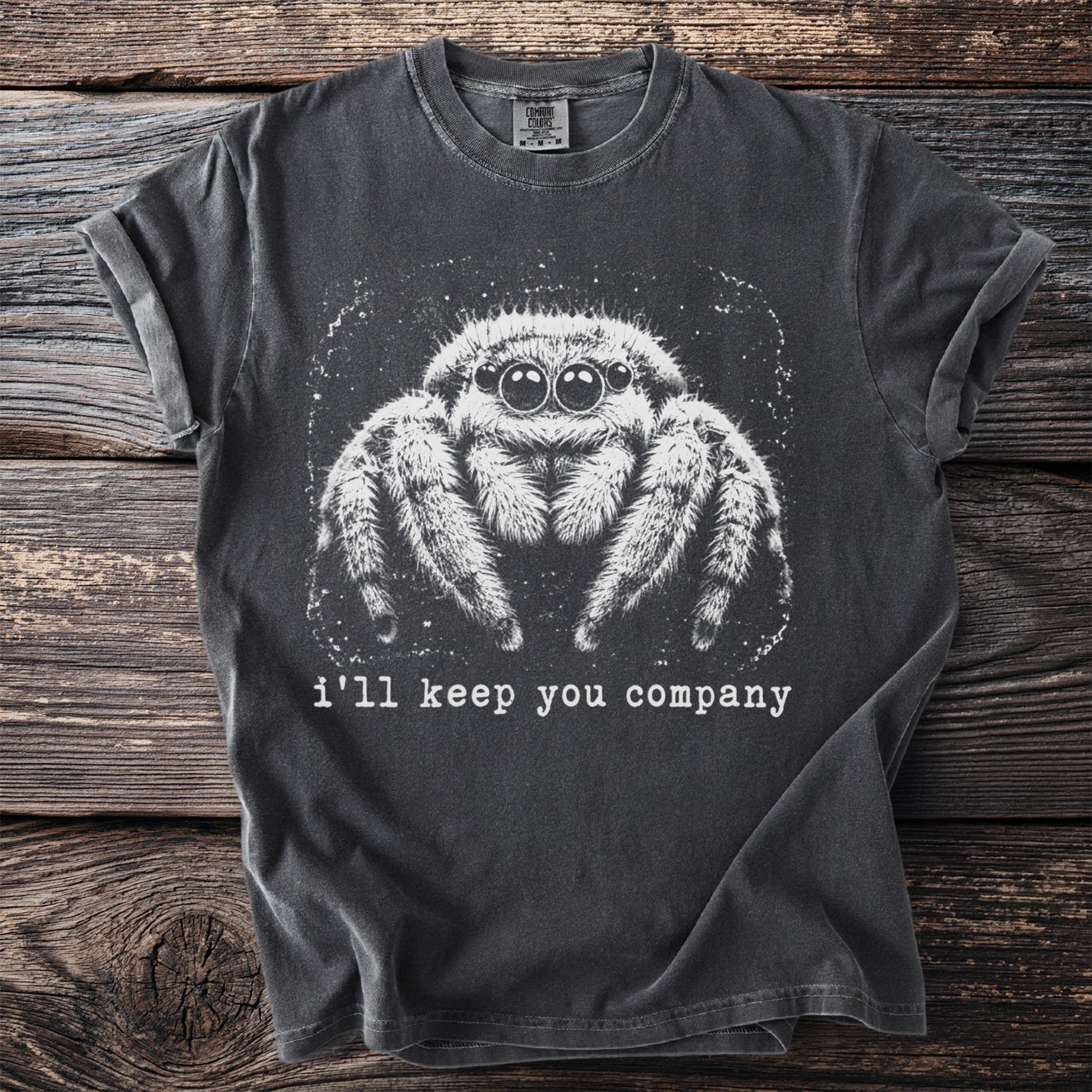 Dark gray t-shirt with white graphic of a jumping spider and text "i'll keep you company".