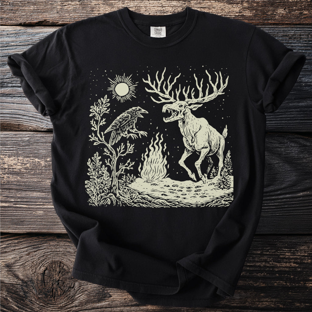 Black t-shirt with graphic of a raven and a skeletal elk by a fire under a starry sky.