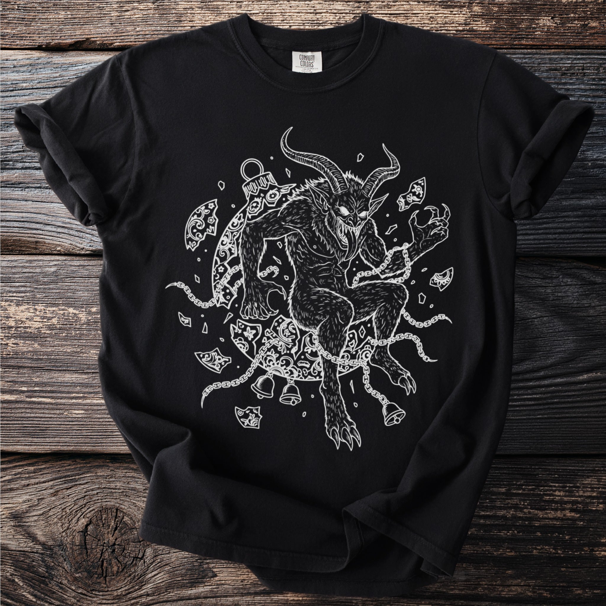Black t-shirt with a white illustration of a horned creature, chains, and bells.