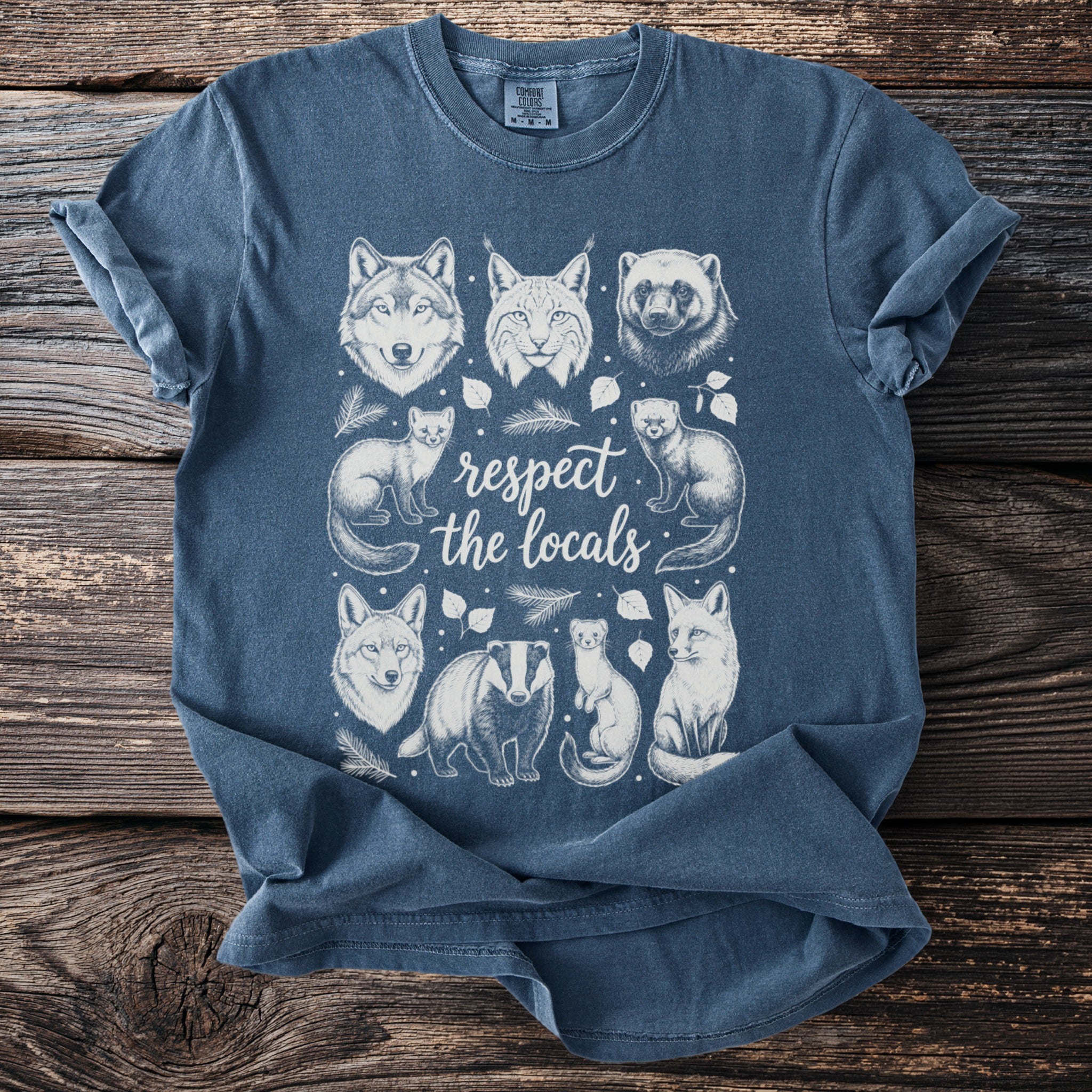 T-shirt with sketch art of wolf, bobcat, wolverine, foxes, badger, and weasels forming "respect the locals".