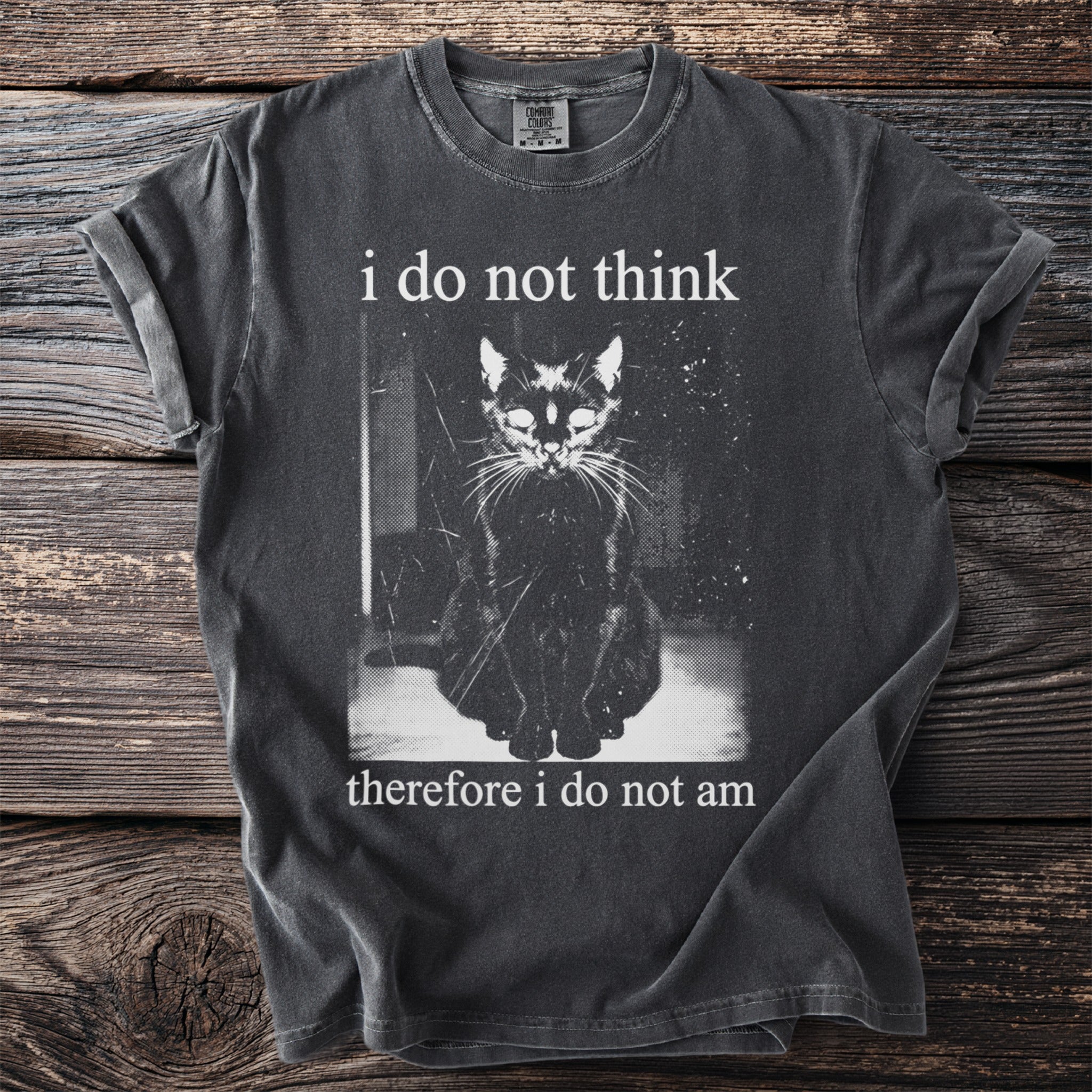 Dark t-shirt with a monochrome graphic of a seated black cat and text.