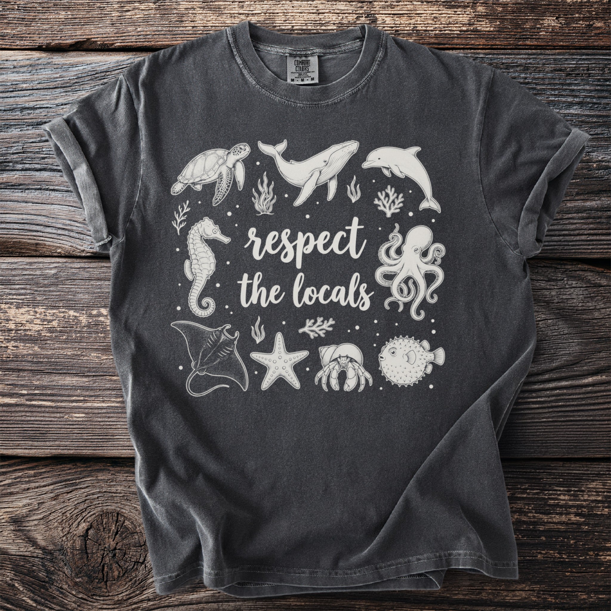 Dark grey t-shirt with white ocean animals and text "respect the locals."