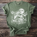Green t-shirt with a graphic of bass jumping from a lake under a full moon.