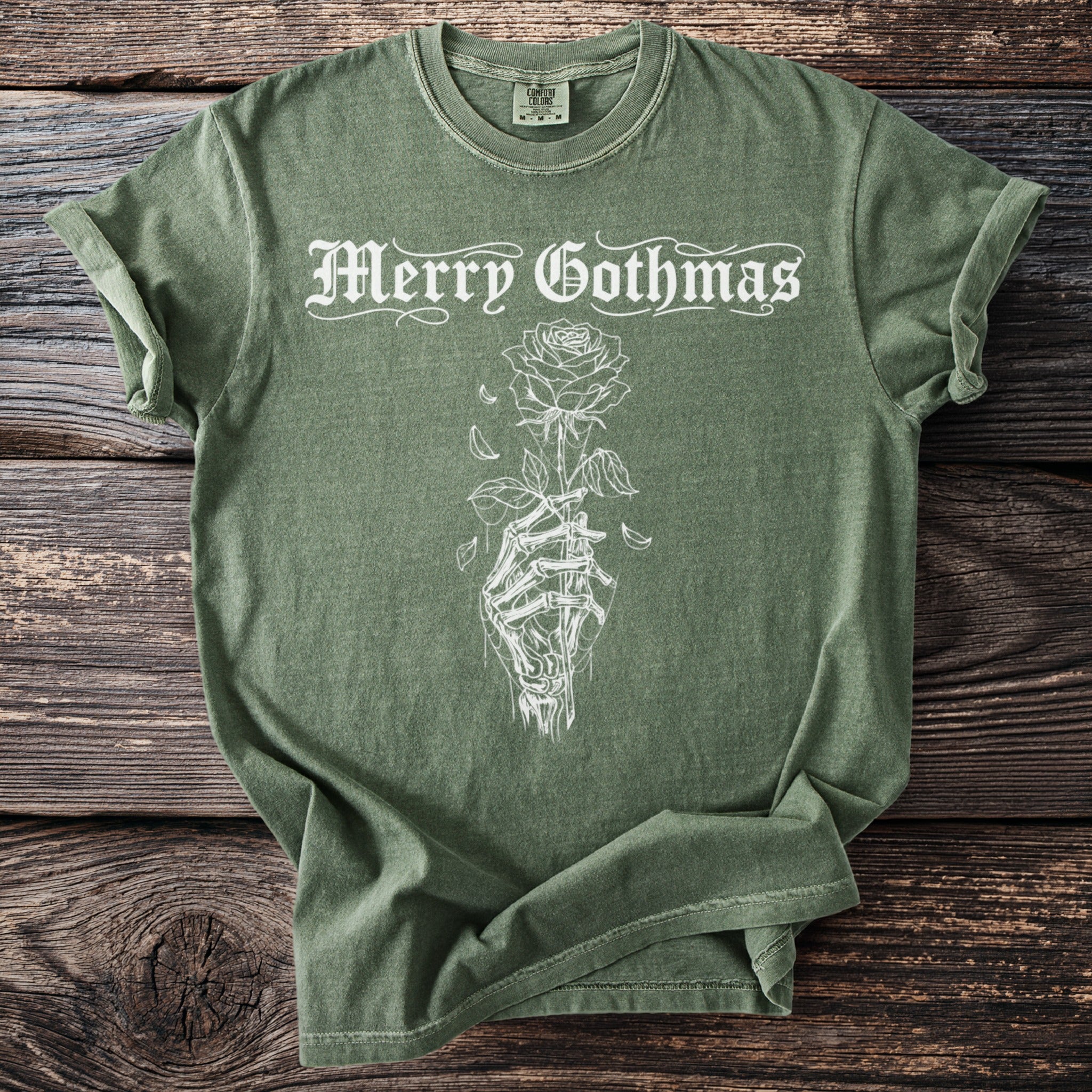 Green t-shirt with "Merry Gothmas" text and a skeleton hand holding a rose.
