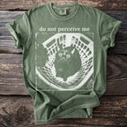 Green t-shirt with a distressed print of a startled cat in a basket and text "do not perceive me".