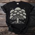 Black t-shirt with a cream-colored linocut-style tree and moon graphic.