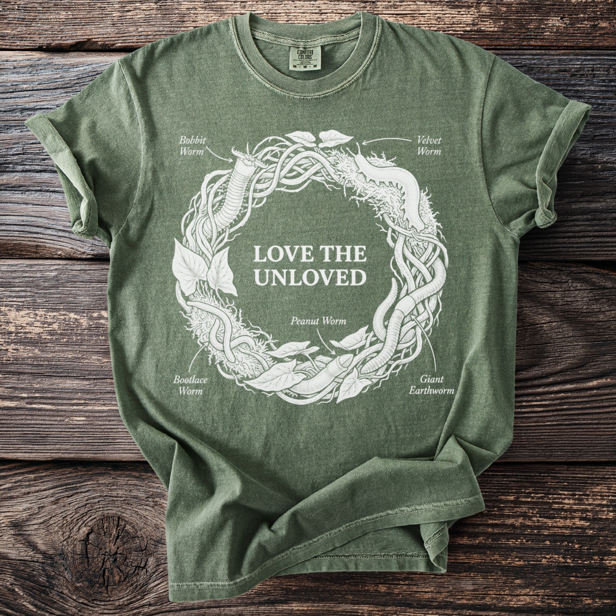 Green t-shirt with circular design of worms, leaves, and text "LOVE THE UNLOVED".