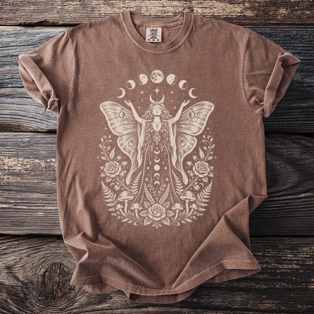 Brown t-shirt with a cream graphic of a moth woman surrounded by moons, roses, and mushrooms.