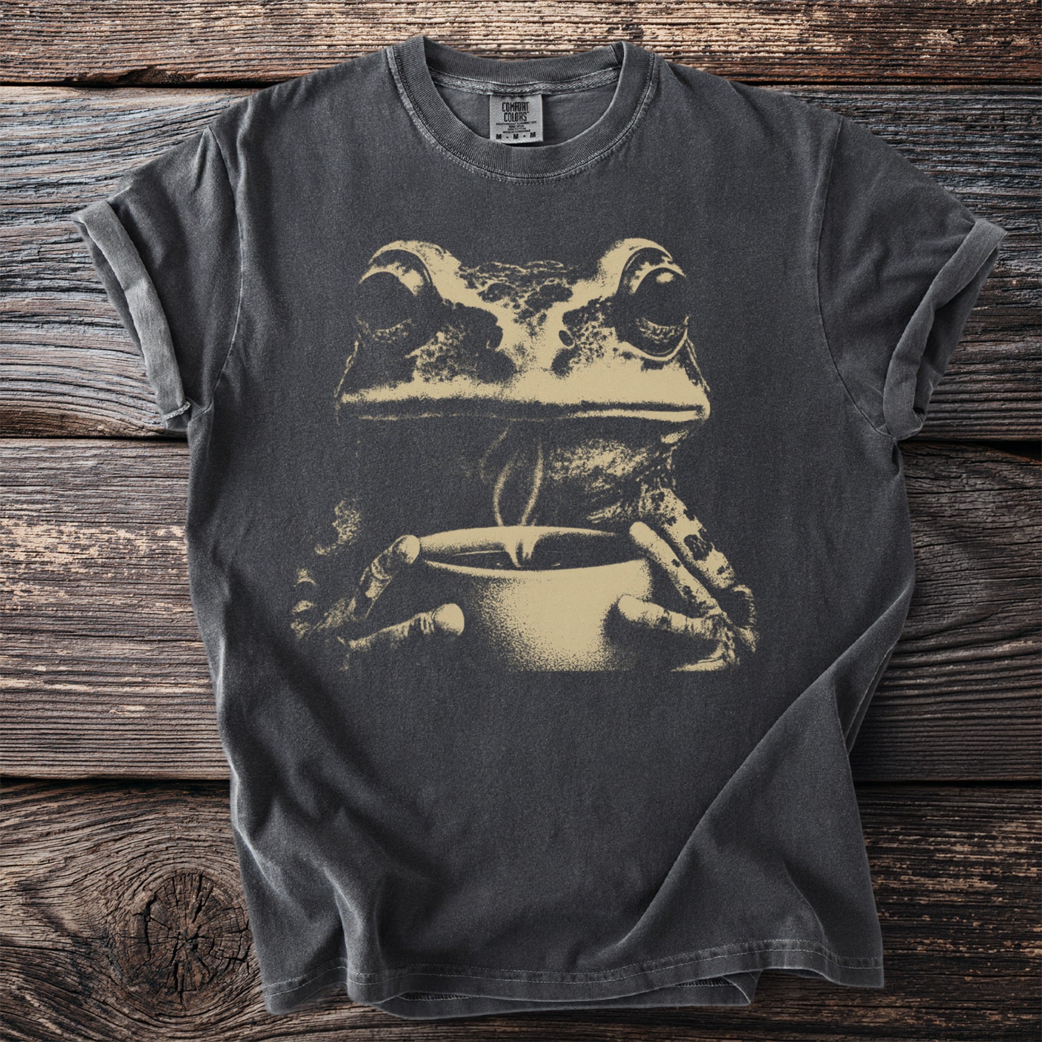 Dark gray t-shirt with a beige graphic of a frog holding a mug.