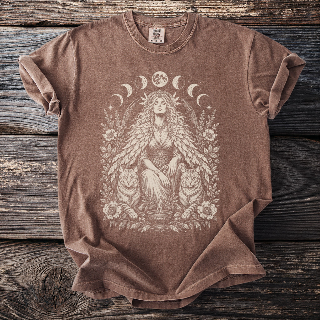 Brown t-shirt with a vintage-style graphic of a woman and cats surrounded by moons and flowers.