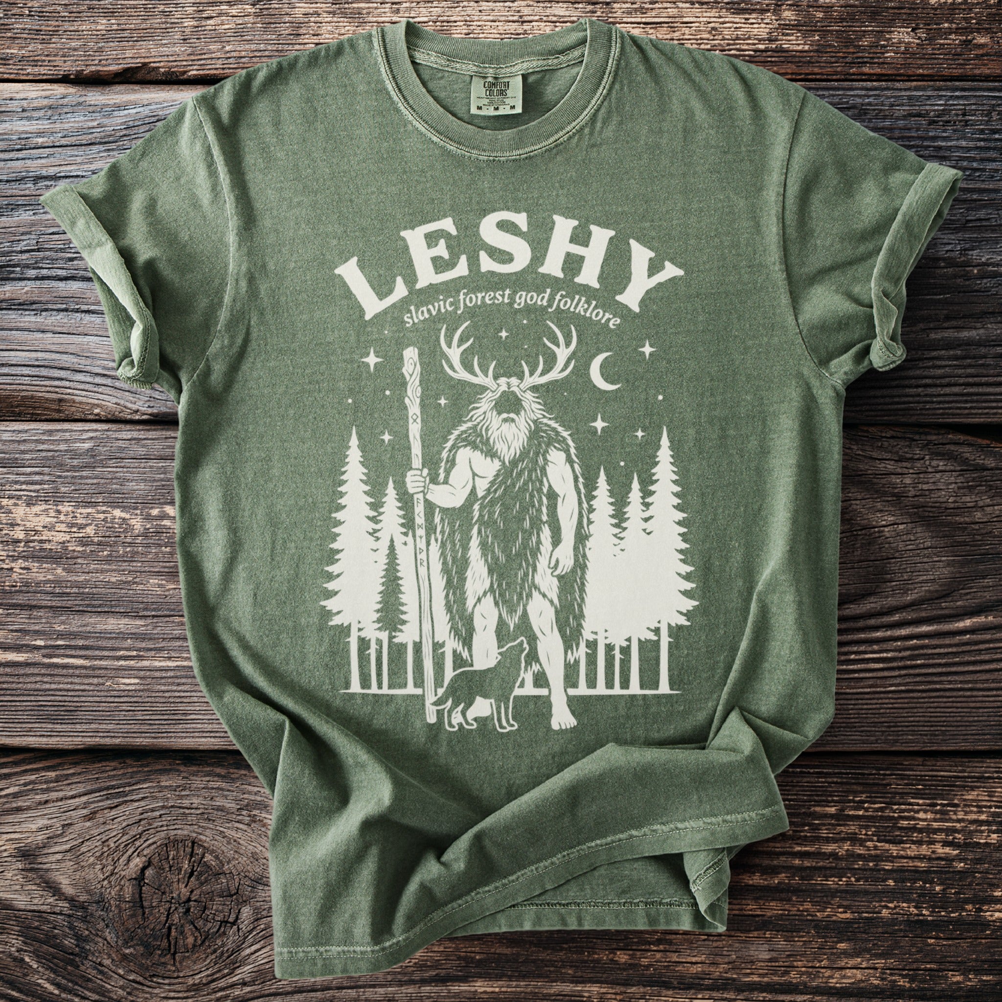 Green t-shirt with "Leshy Slavic forest god folklore" and forest deity graphic.