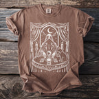 Brown t-shirt with white occult graphic featuring a robed figure, crystal ball, tarot cards, and a cat.