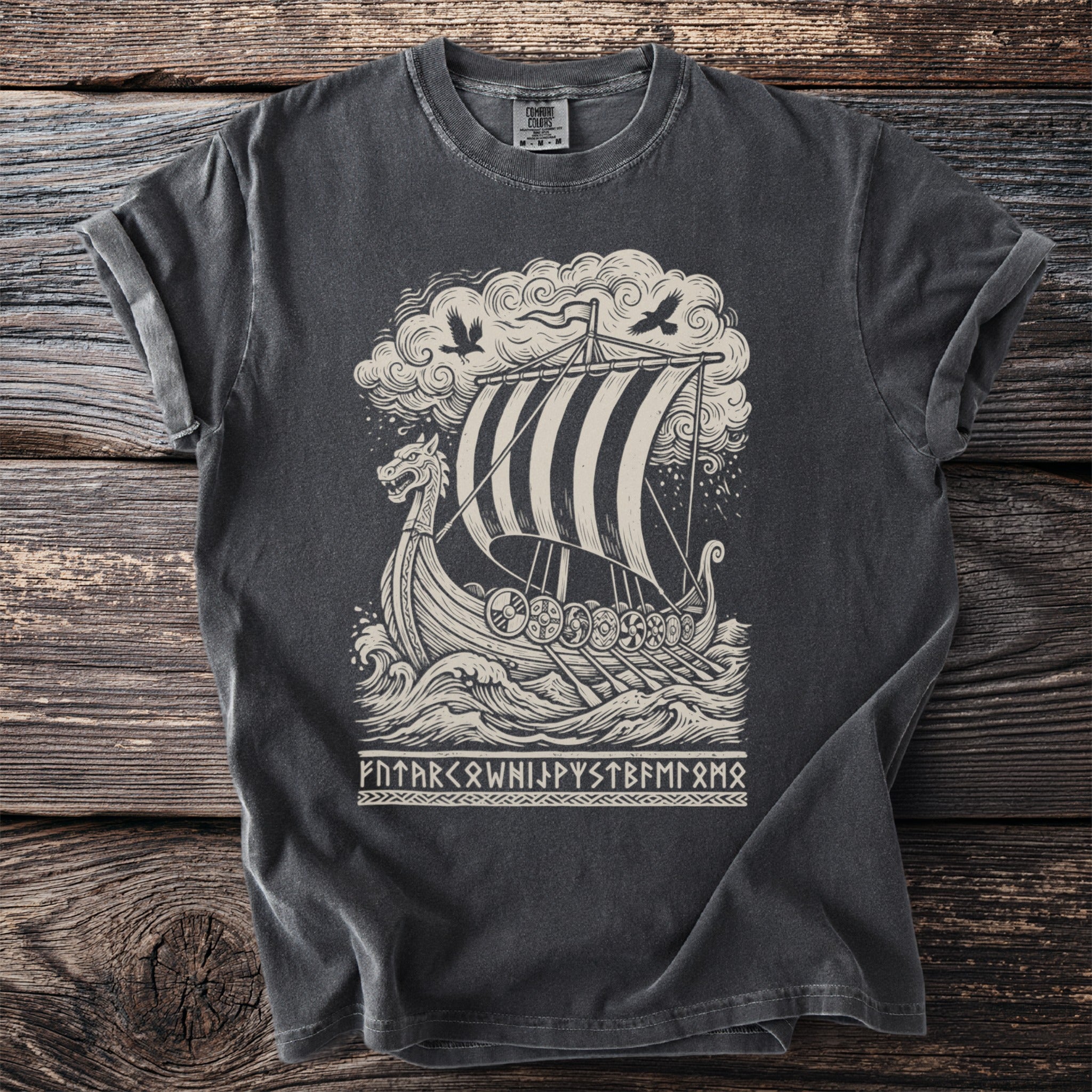 T-shirt graphic of a Viking ship sailing through rough seas with birds and runes.