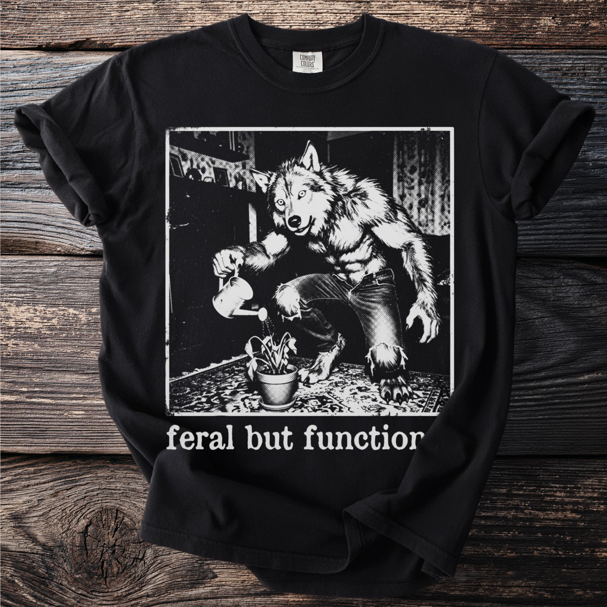 Werewolf watering a plant with text "feral but function" on a black t-shirt.
