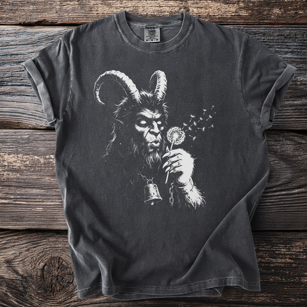 Charcoal gray t-shirt with a white graphic of Krampus blowing dandelion seeds, wearing a bell.