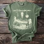 Green t-shirt with graphic of wolves, skull, moon, and standing stones.