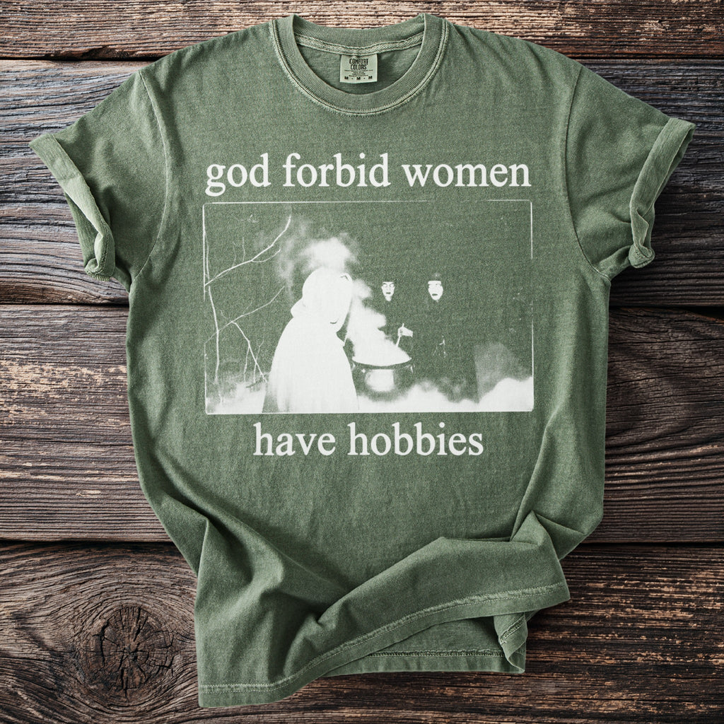 Green t-shirt with "god forbid women have hobbies" text and witchy image.