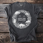 T-shirt with a white circular design of "Love the Unloved" animals and text.