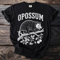 Black t-shirt with white text "OPOSSUM" and graphic of an opossum on a branch.