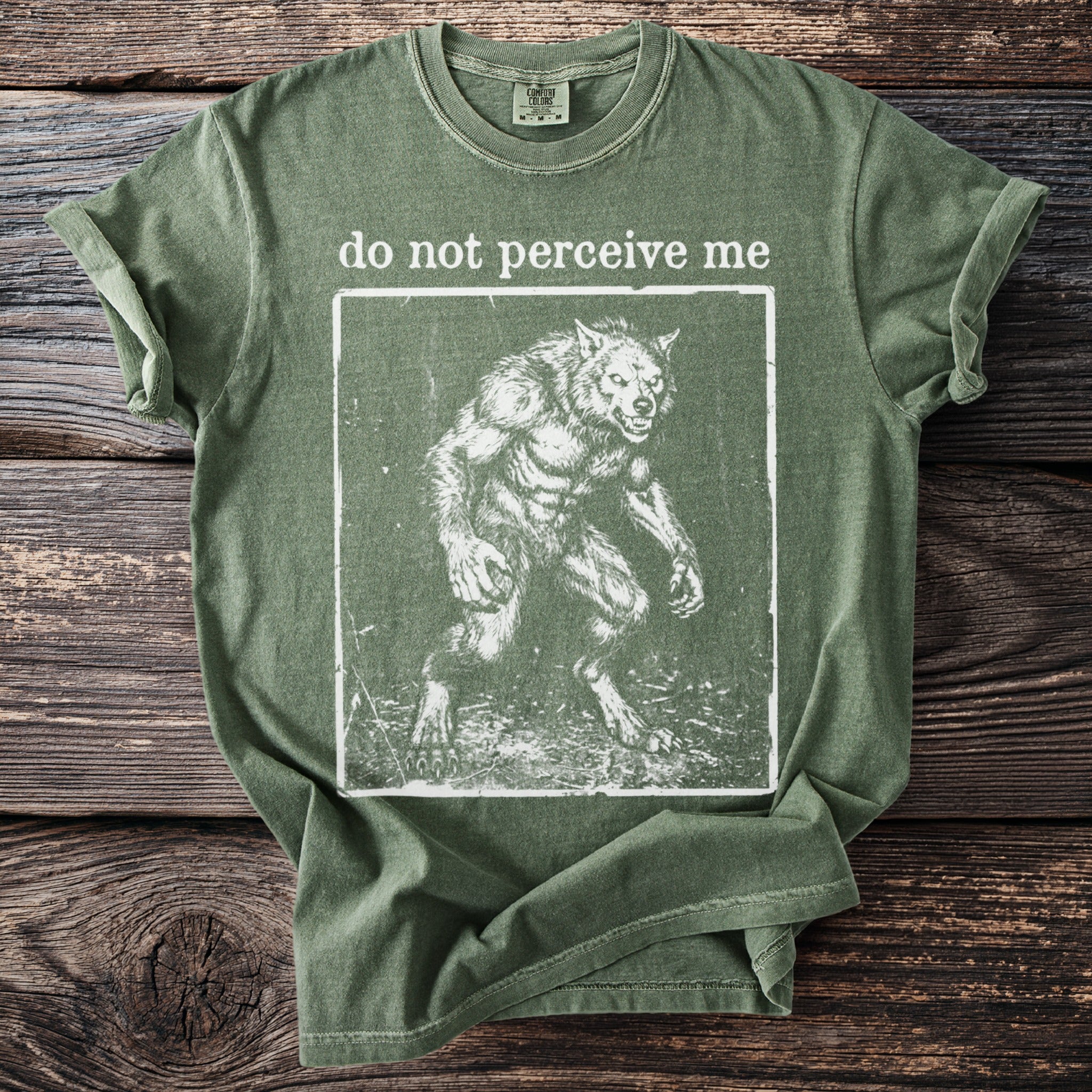 Green t-shirt with "do not perceive me" and a werewolf graphic.