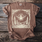 T-shirt with an alien design over a forest and lake scene.