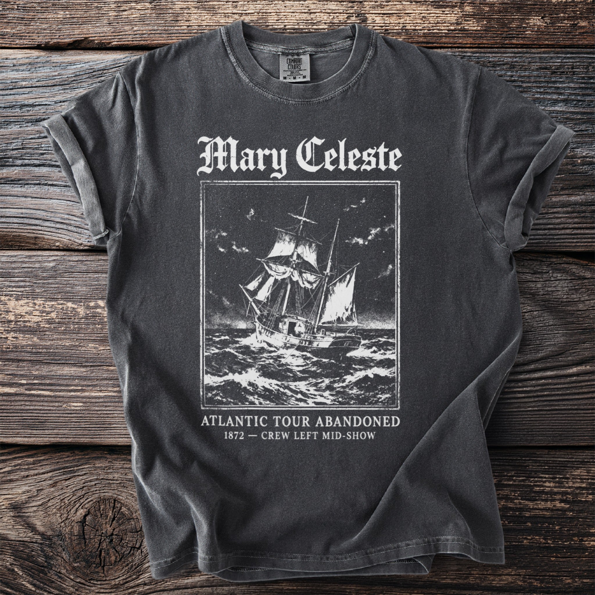 Dark t-shirt with a vintage illustration of the Mary Celeste ship and text.