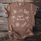 Brown t-shirt with white line art butterfly, bee, flowers, and text "respect the locals".