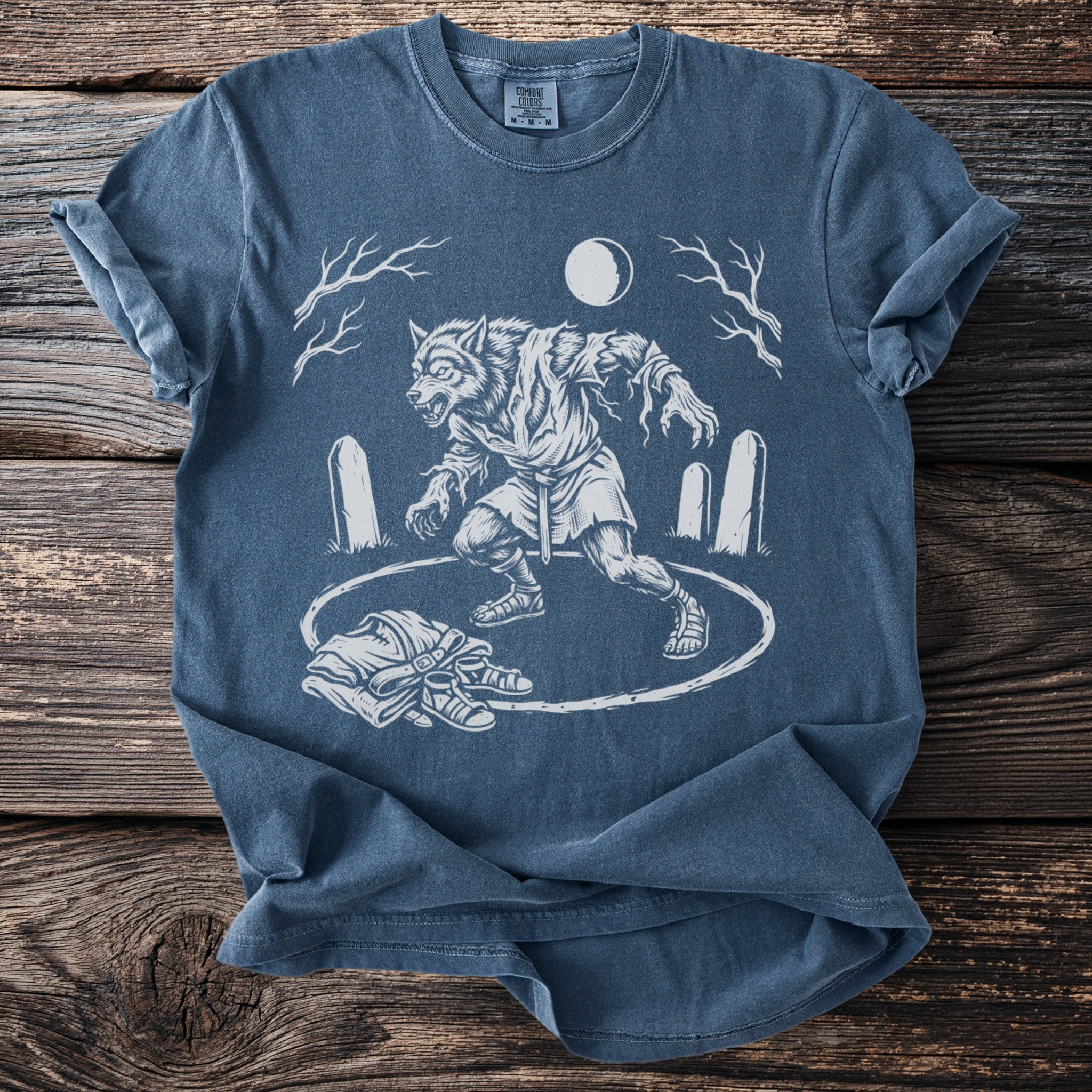 T-shirt with werewolf transformation illustration in circle, moon, trees, and gravestones.