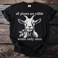 Black t-shirt with white goat eating a branch, text "all plants are edible some only once".