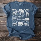 Blue t-shirt with safari animals and text "respect the locals" in white.