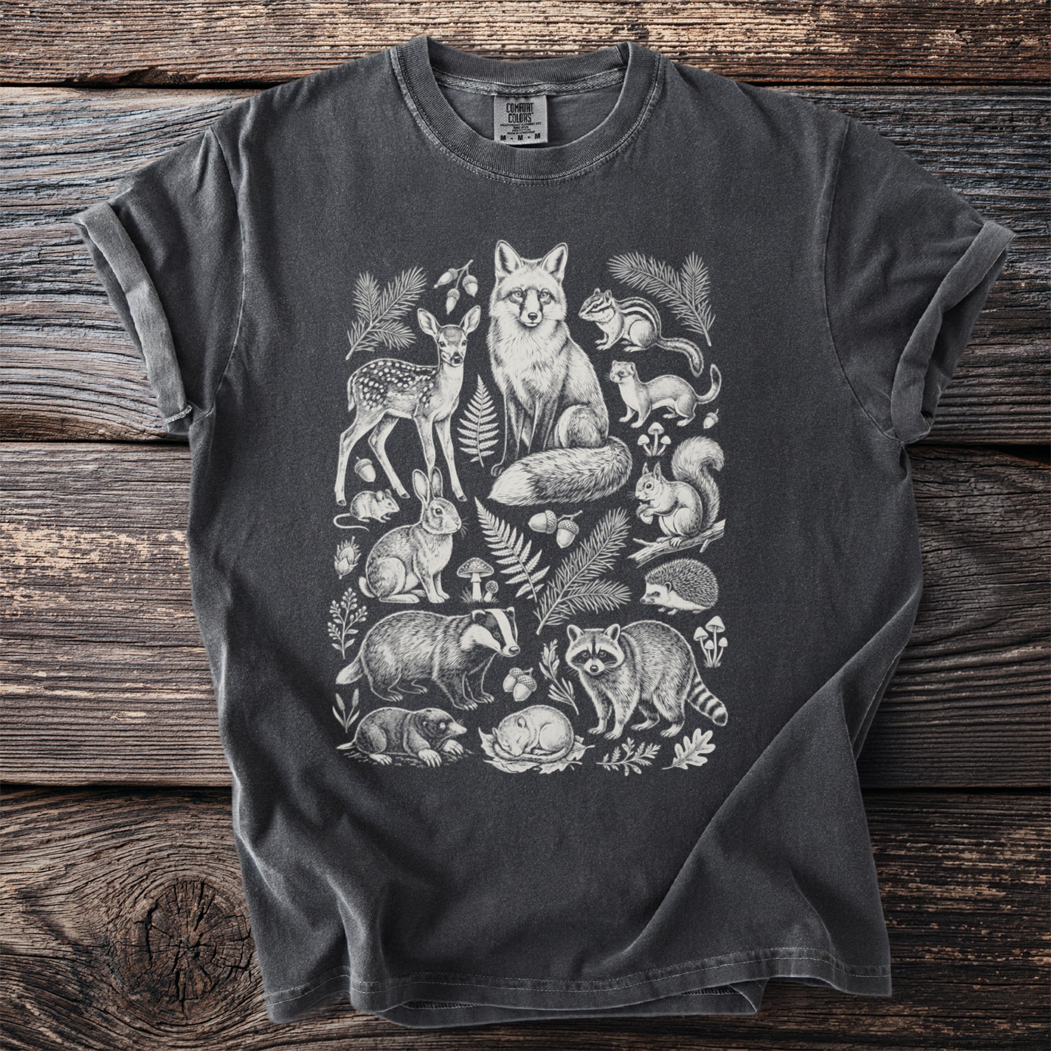 Charcoal t-shirt with a white line drawing of forest animals and foliage.