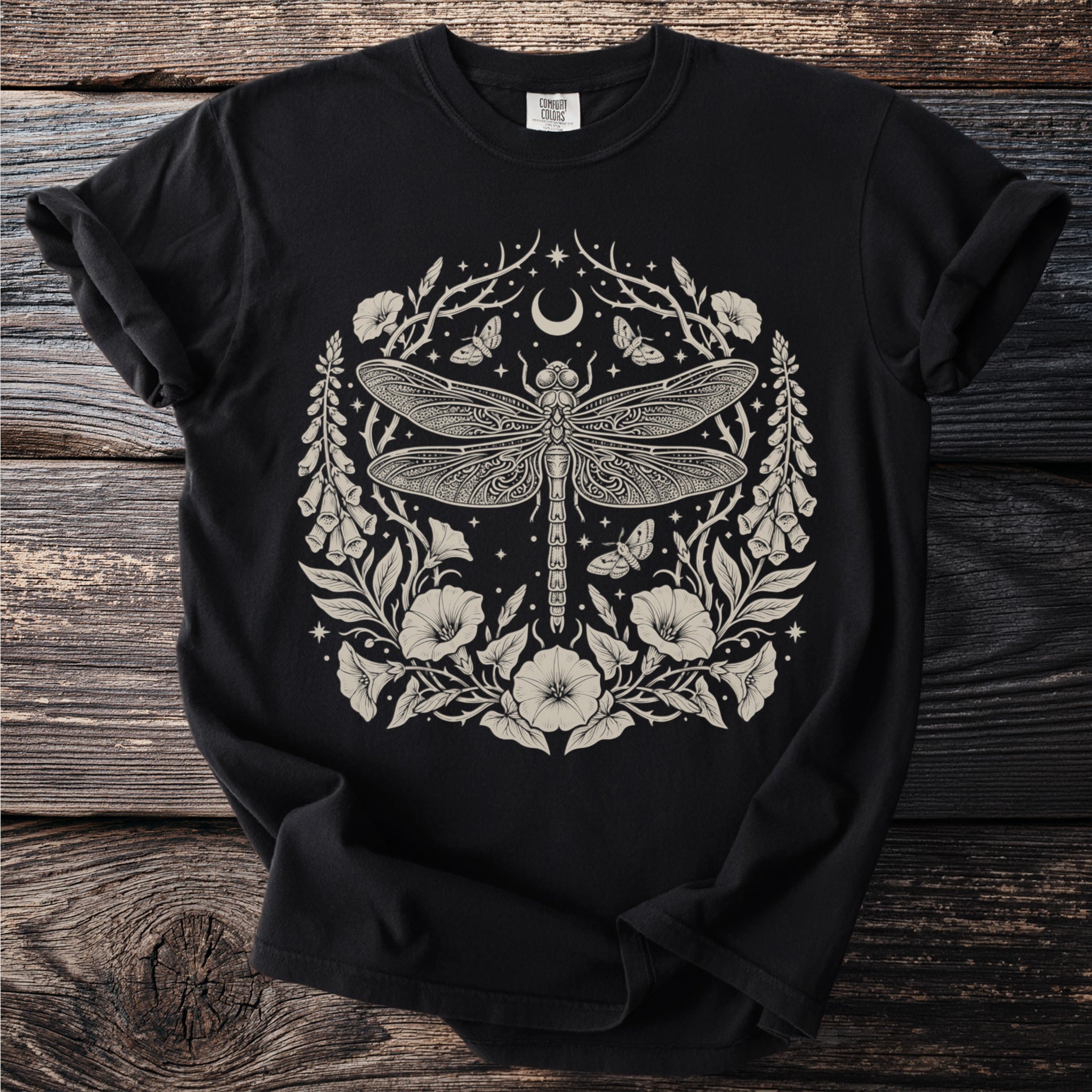 Black t-shirt with a circular cream-colored dragonfly and floral design.
