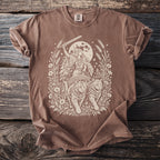 Brown t-shirt with a cream-colored illustration of a woman in a chariot pulled by two cats.