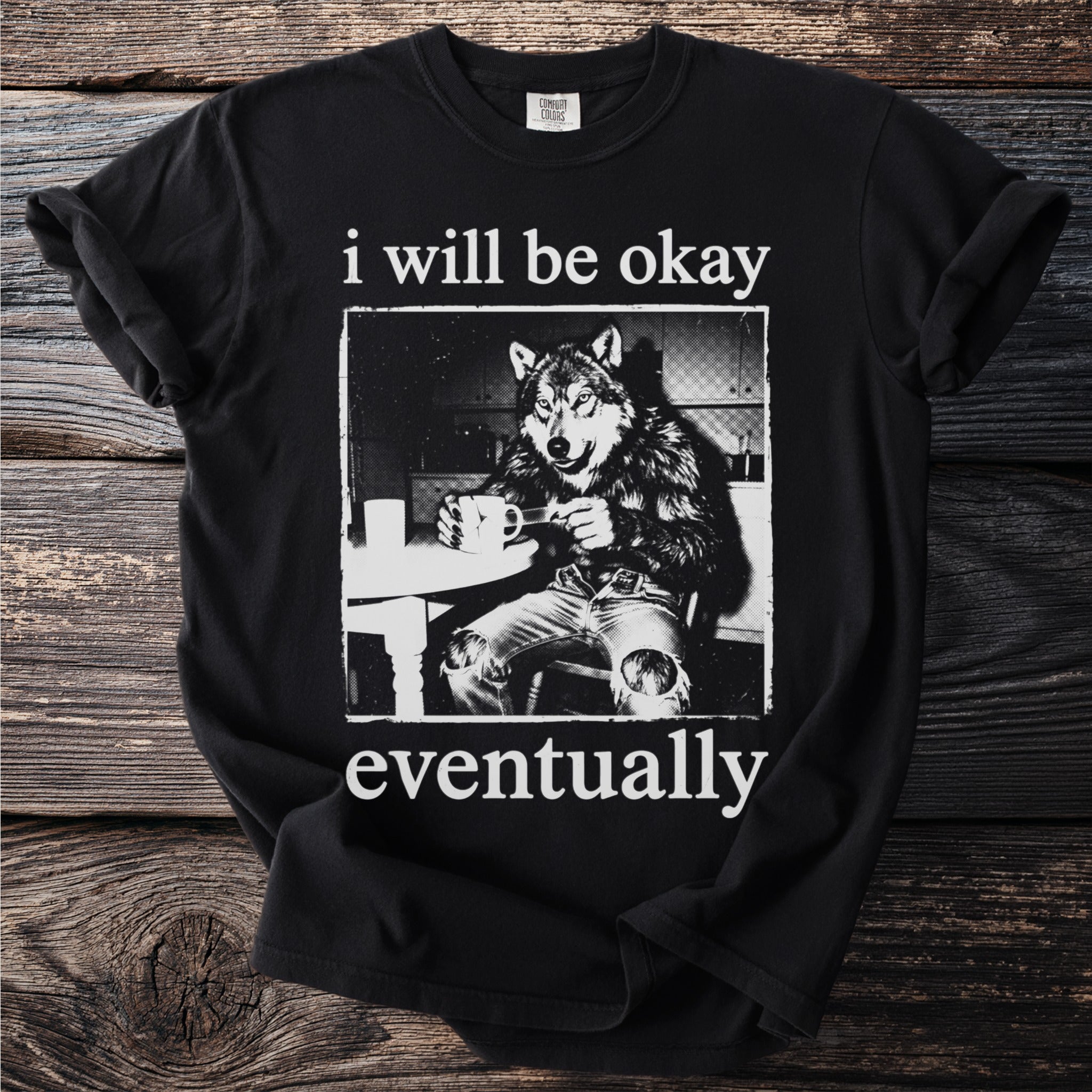 Black t-shirt with wolf character sitting at a table holding a mug and text.