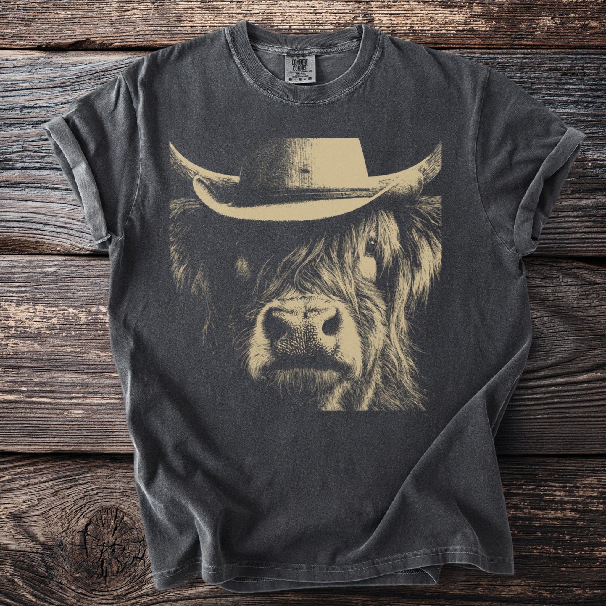 Dark gray t-shirt with a tan line drawing of a cow wearing a cowboy hat.